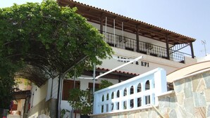 A building with a stone facade, a wooden balcony, and a staircase leading to the entrance. - Litsa Efi (Hersonissos)