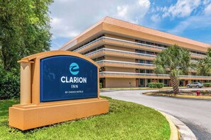 Et Clarion Inn hotel fra Choice Hotels med en fleretasjes bygning, en parkeringsplass og et skilt.