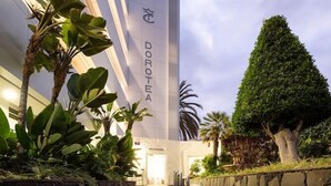 A modern building with a Dorothea A sign, a stone wall, and a staircase leading to the entrance. - TC Apartamentos Dorotea (San Bartolomé de Tirajana)