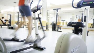 Un gimnasio con equipo de ejercicio, incluyendo una cinta de correr y una bicicleta estática.