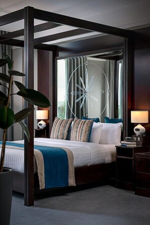 A hotel room with a bed, bedside tables, a large window with curtains, and a decorative wall piece. - Carlton Hotel Blanchardstown (Dublin)