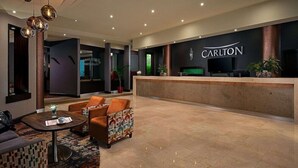 A hotel lobby with a reception desk, seating area, and a modern chandelier. - Carlton Hotel Blanchardstown (Dublin)