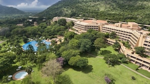 Ein großes Resort mit mehreren Gebäuden, einem Schwimmbad und üppiger Vegetation.