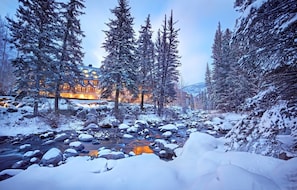 A snow-covered landscape with a lodge featuring multiple windows and a lit exterior. - Grand Hyatt Vail Resort and Spa (Vail)