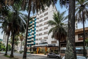 Un hotel de varios pisos con diseño moderno, con balcones y un letrero llamativo que dice 'Azor'.