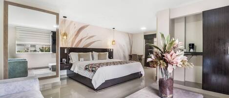 A modern bedroom with a large bed, bedside tables, a nightstand, a vase with flowers, and a view of the outside.