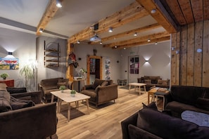 A cozy interior with wooden beams, a fireplace, and comfortable seating areas. - Laxnes Hotel (Mosfellsbær)