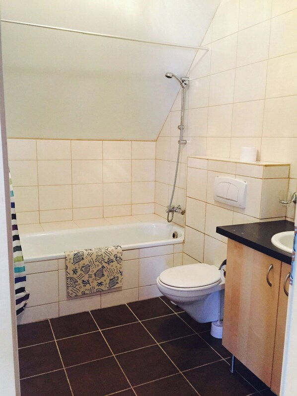 A bathroom with a bathtub, toilet, and sink. - Laxnes Hotel (Mosfellsbær)