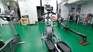 Une salle de sport équipée de divers appareils d’exercice, notamment des tapis de course, des appareils elliptiques et des appareils de musculation.
