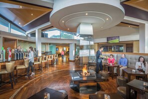 Een ruime lobby met een bar, zithoekjes en een sfeervol haardvuur.