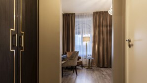 A hotel room with a desk, chair, and a lamp. - Home Hotel Grand, Gjovik (Gjovik)
