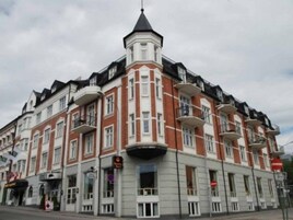 Un edificio de varios pisos con una torre angular característica y balcones.
