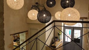 A staircase with a wrought iron railing and multiple spherical pendant lights.