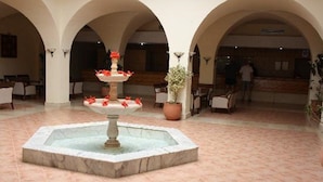 A lobby with a central fountain, arched ceilings, and a reception area. - Oasis Marine (Zarzis)