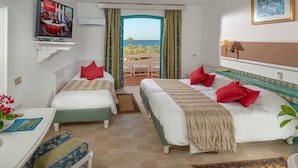 A hotel room with two beds, a TV, a desk, and a view of the sea. - Oasis Marine (Zarzis)