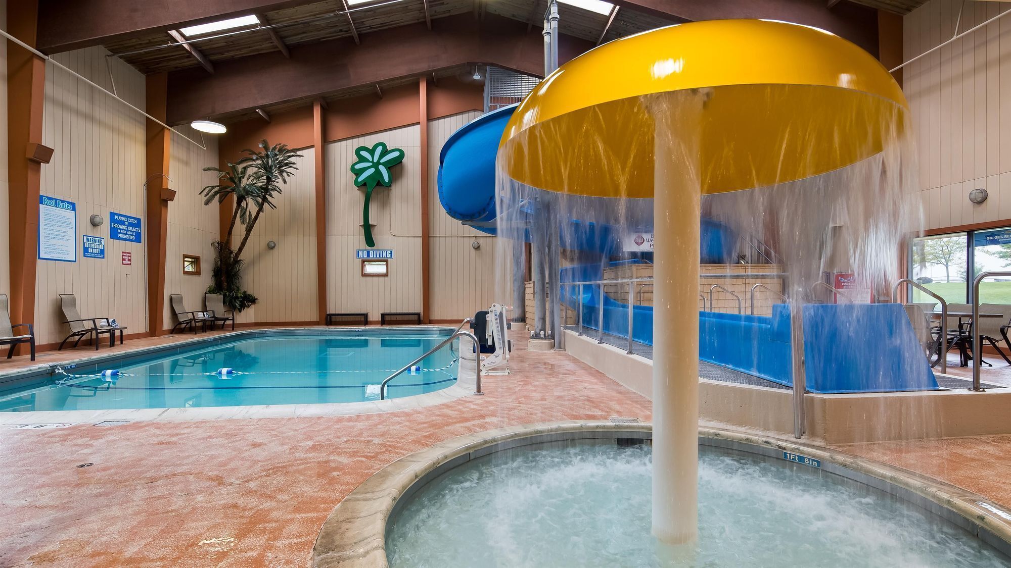 Ein Hallenbad mit Wasserrutsche und Whirlpool.