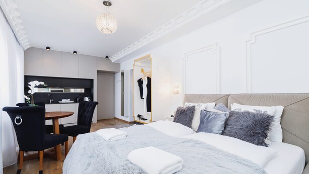 Une chambre d’hôtel moderne dotée d’un grand lit, d’un coin repas et d’une kitchenette.