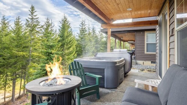 Un espacio al aire libre techado con una chimenea, asientos y tinacos hidromasajables.