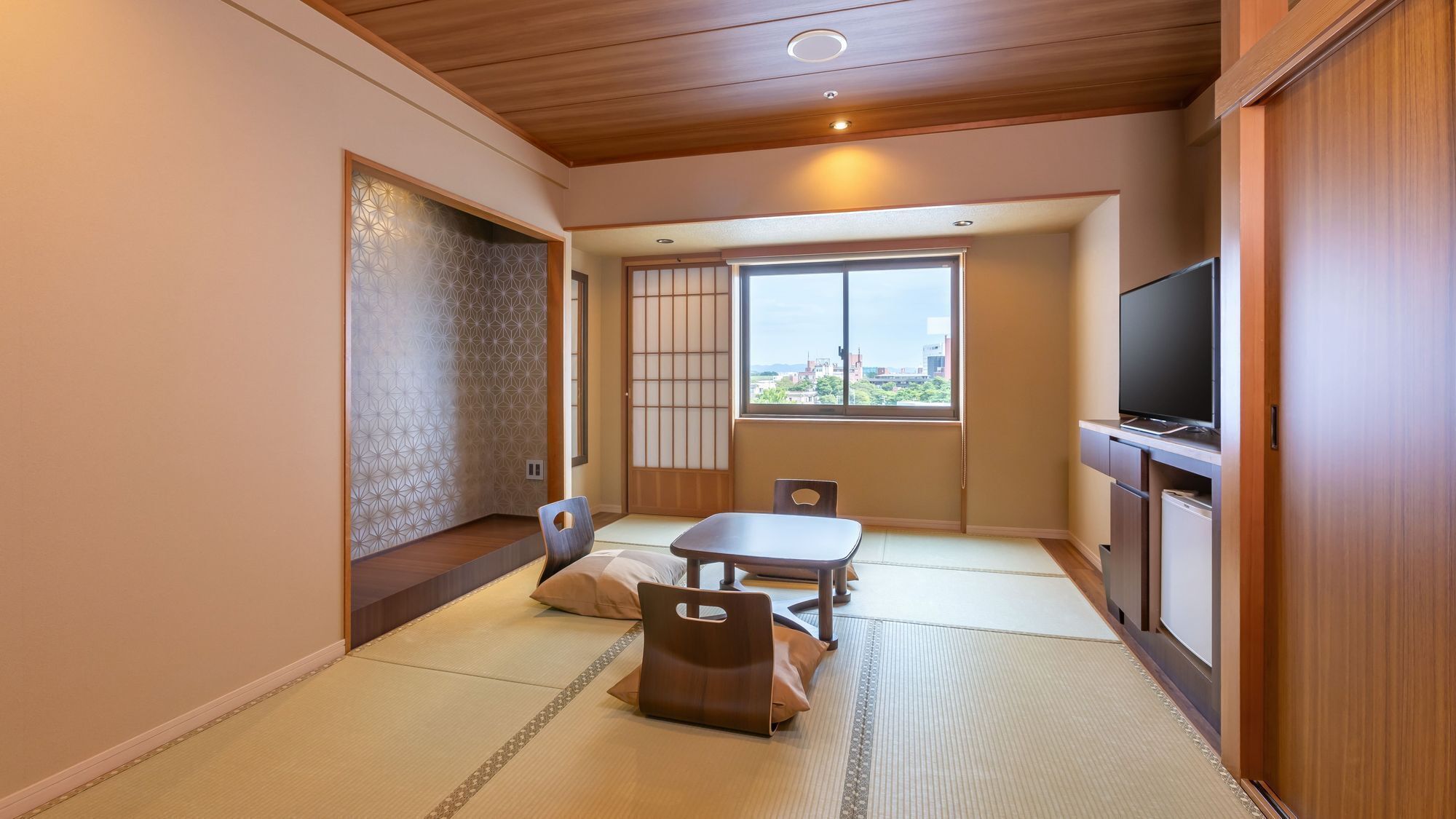A traditional Japanese-style room with tatami flooring, a low table, and a television.