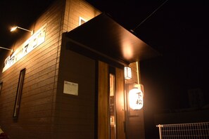 Un bâtiment doté d’une façade en bois et d’une enseigne lumineuse.