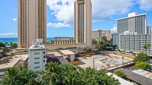 A high-rise hotel with multiple floors, a beach view, and a construction site nearby.