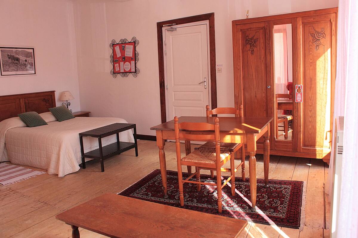 A bedroom with a bed, bedside table, and a wooden chair.