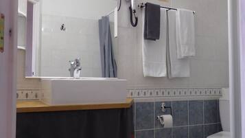 Kylpyhuone, jossa on pesuallas, peili, pyyhekoukku ja wc.