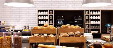 A bakery counter with bread, pastries, and condiments.