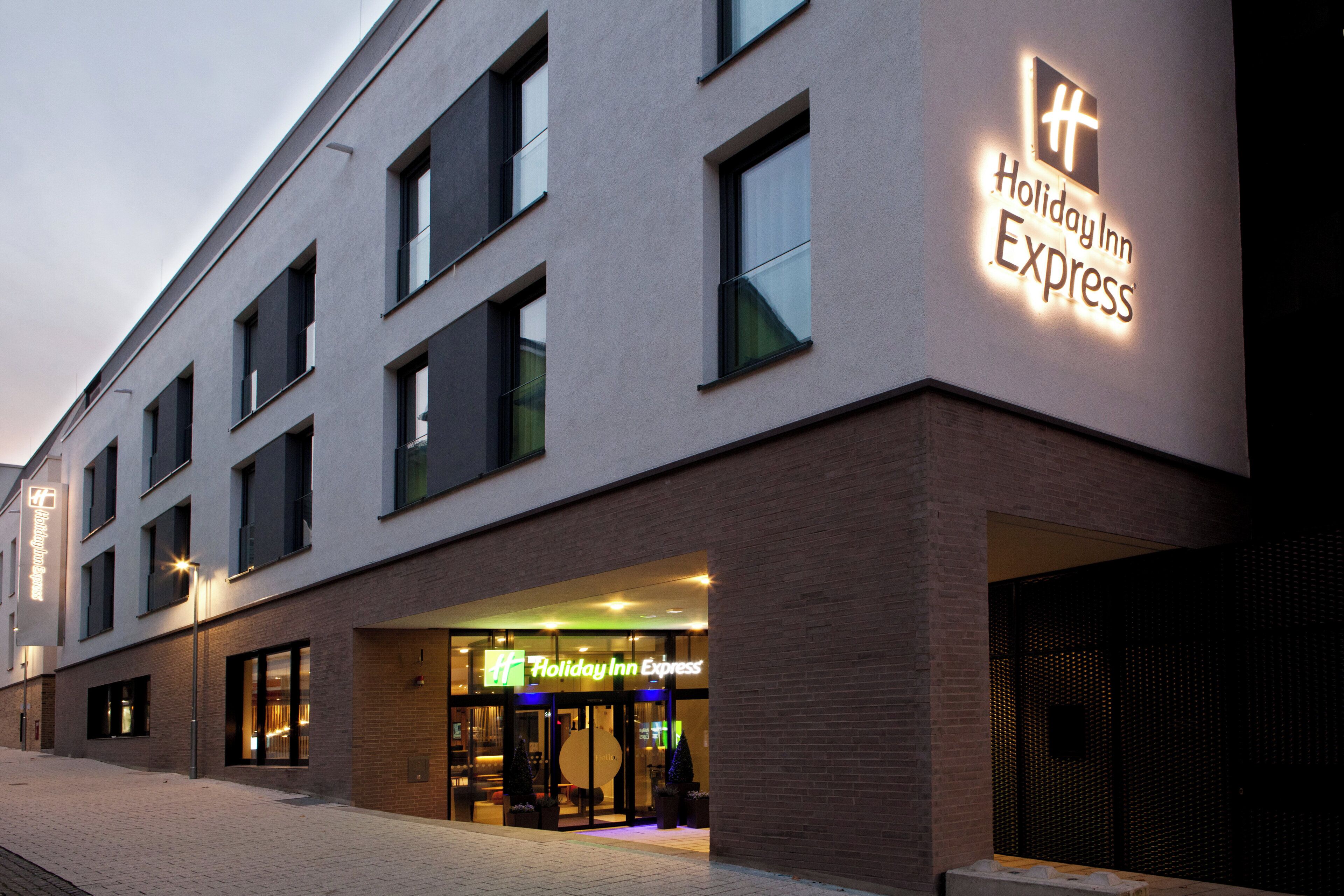 Un bâtiment de l’hôtel Holiday Inn Express doté d’une façade moderne, de grandes fenêtres et d’une entrée bien visible.