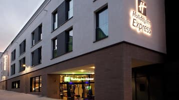 Un bâtiment de l’hôtel Holiday Inn Express doté d’une façade moderne, de grandes fenêtres et d’une entrée bien visible.