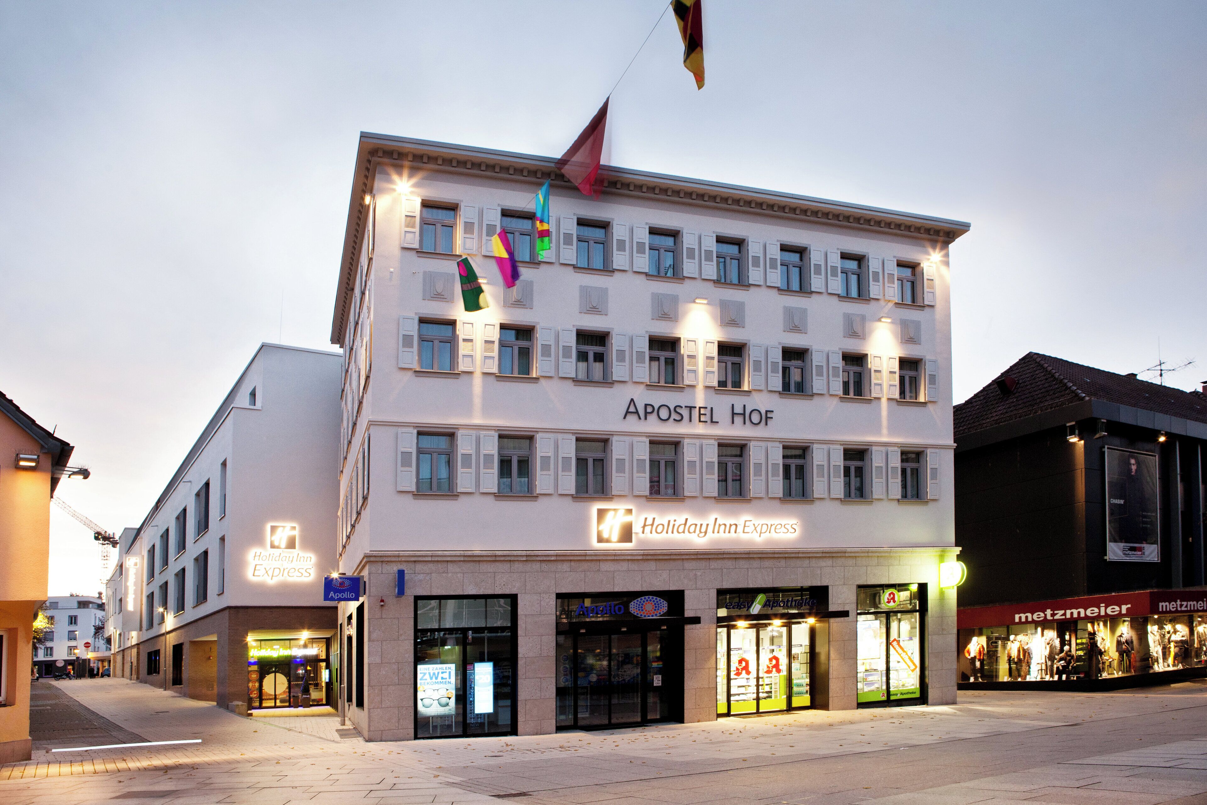 A multi-story building with the name 'Apostel Hof' and 'Holiday Inn Express' signage.