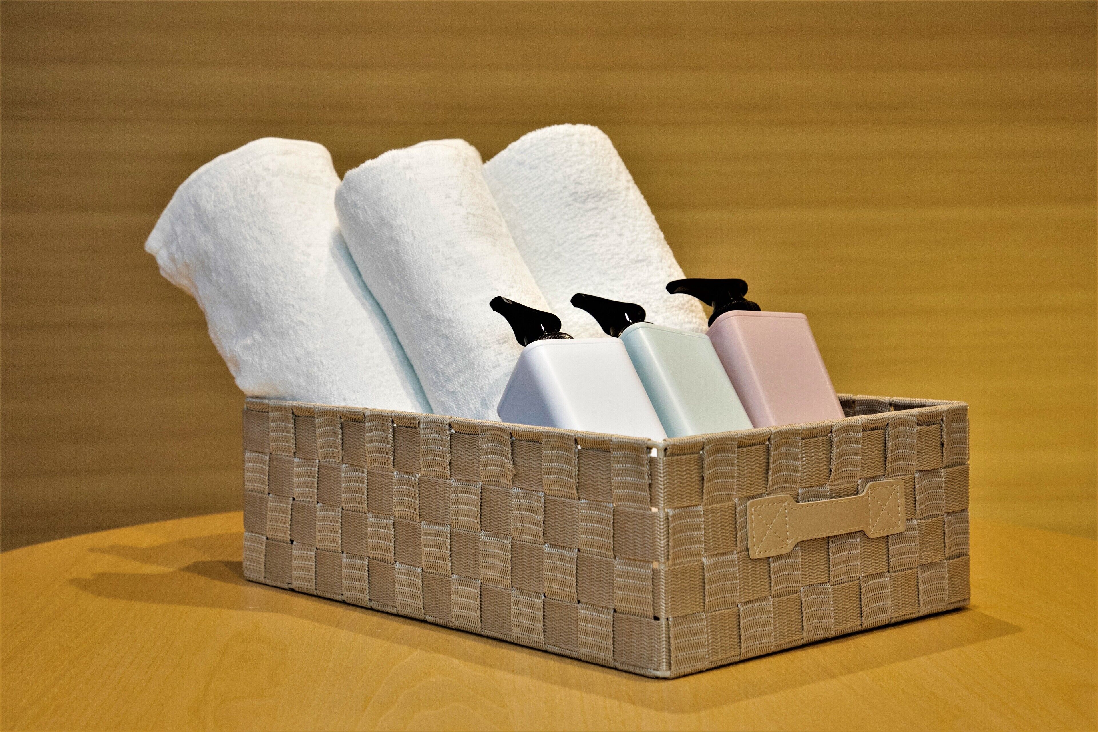 Un panier en osier contenant des serviettes et des articles de toilette.