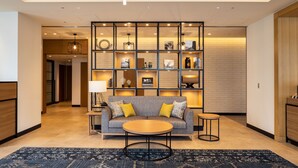 A modern living room with a sofa, coffee table, and a decorative wall unit. - JR East Hotel Mets Premier Yokohama Sakuragicho (Yokohama)