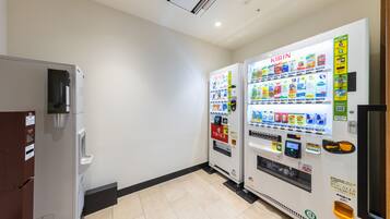 A vending machine area with a refrigerator and a vending machine labeled 'KIRIN'.