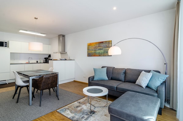 A modern living space with a dining area, sofa, and a small side table.