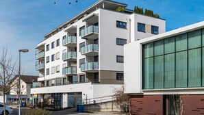 Un immeuble à plusieurs étages doté de balcons, de grandes fenêtres et d’un style architectural moderne.