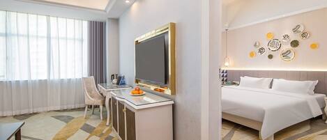 Une chambre d’hôtel comprenant un lit, un bureau avec une chaise, une télévision et un mur décoré d’assiettes.