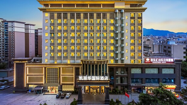 Um hotel grande com vários andares, entrada destacada e uma bandeira na frente.