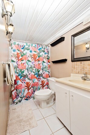 Een bad/douchecombinatie, zeep, shampoo, toiletpapier