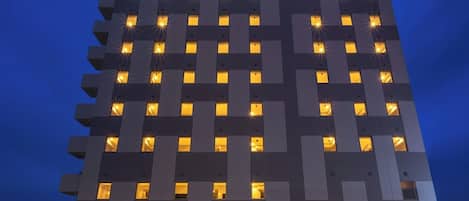 A SuperHotel with a modern design, featuring numerous windows and a prominent sign at the top.