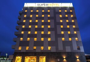Un SuperHotel de diseño moderno, con numerosas ventanas y un cartel llamativo en la parte superior.