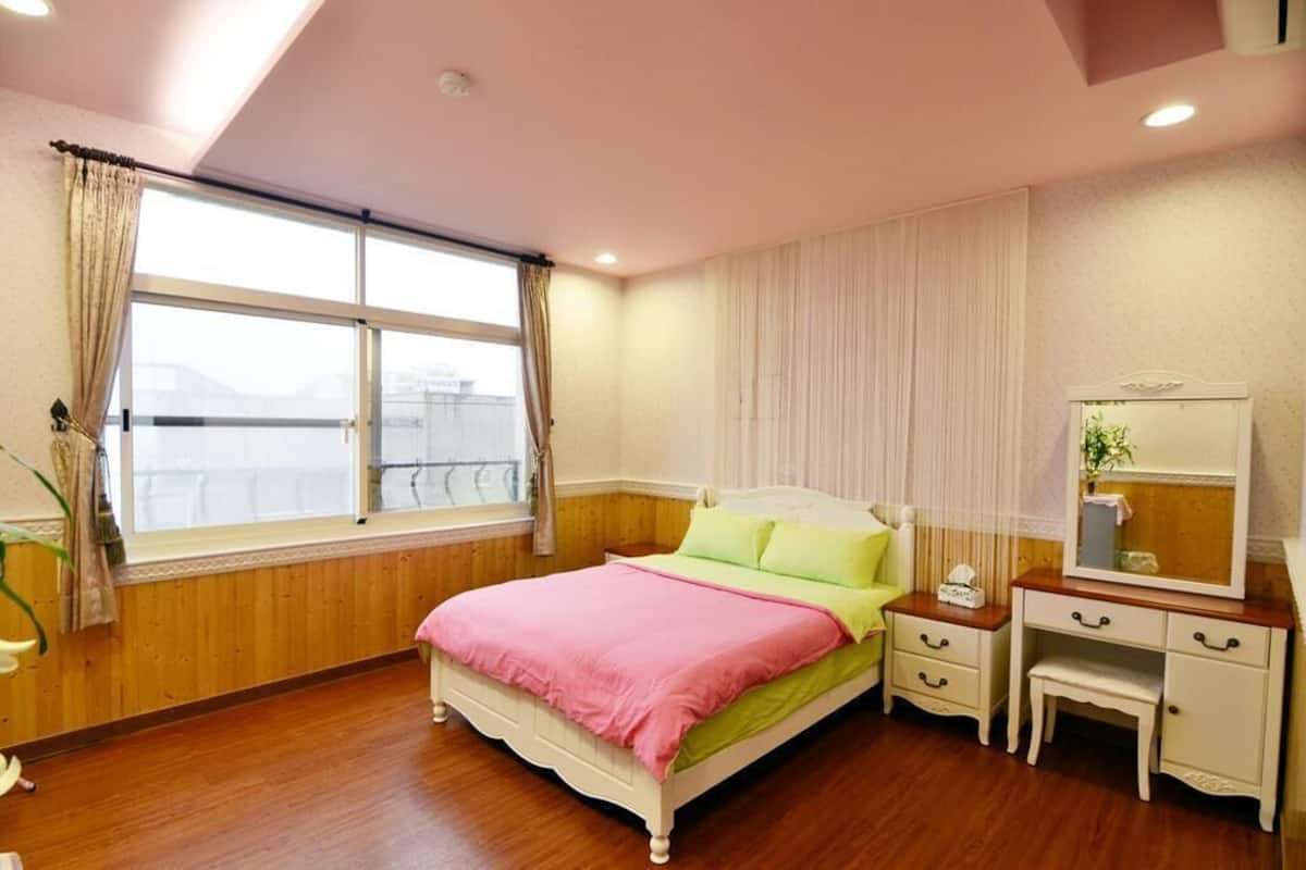 A bedroom with a bed, bedside table, and a dresser.