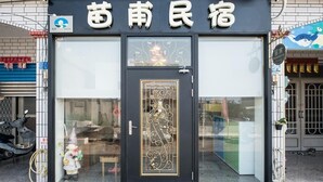 Fachada negra con una puerta dorada decorativa.