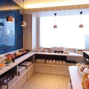 A modern kitchen with a breakfast buffet, blue tiles, hanging pendant lights, and a large window.