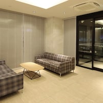 A modern interior with a sofa, a small table, and a glass partition.