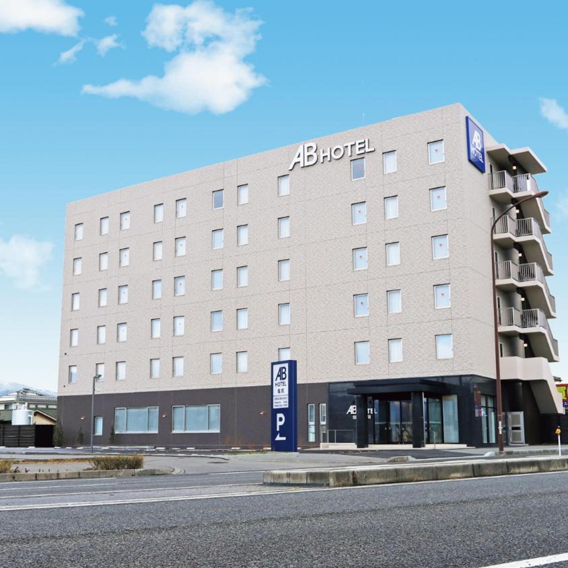 A multi-story hotel building with a flat facade, numerous windows, and a sign indicating it is an AB Hotel.