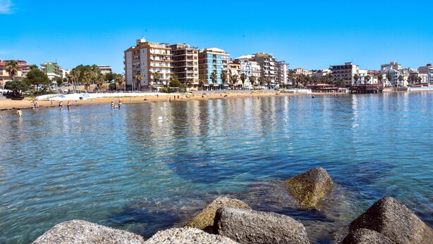 A coastal cityscape with a clear blue sky, a sandy beach, and a calm sea. - B&B Audafra (Crotone)