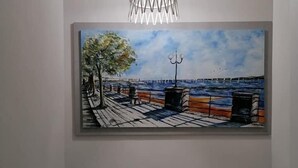 A painting of a dock with a tree and a body of water, a pendant light above, and a potted plant below. - B&B Audafra (Crotone)