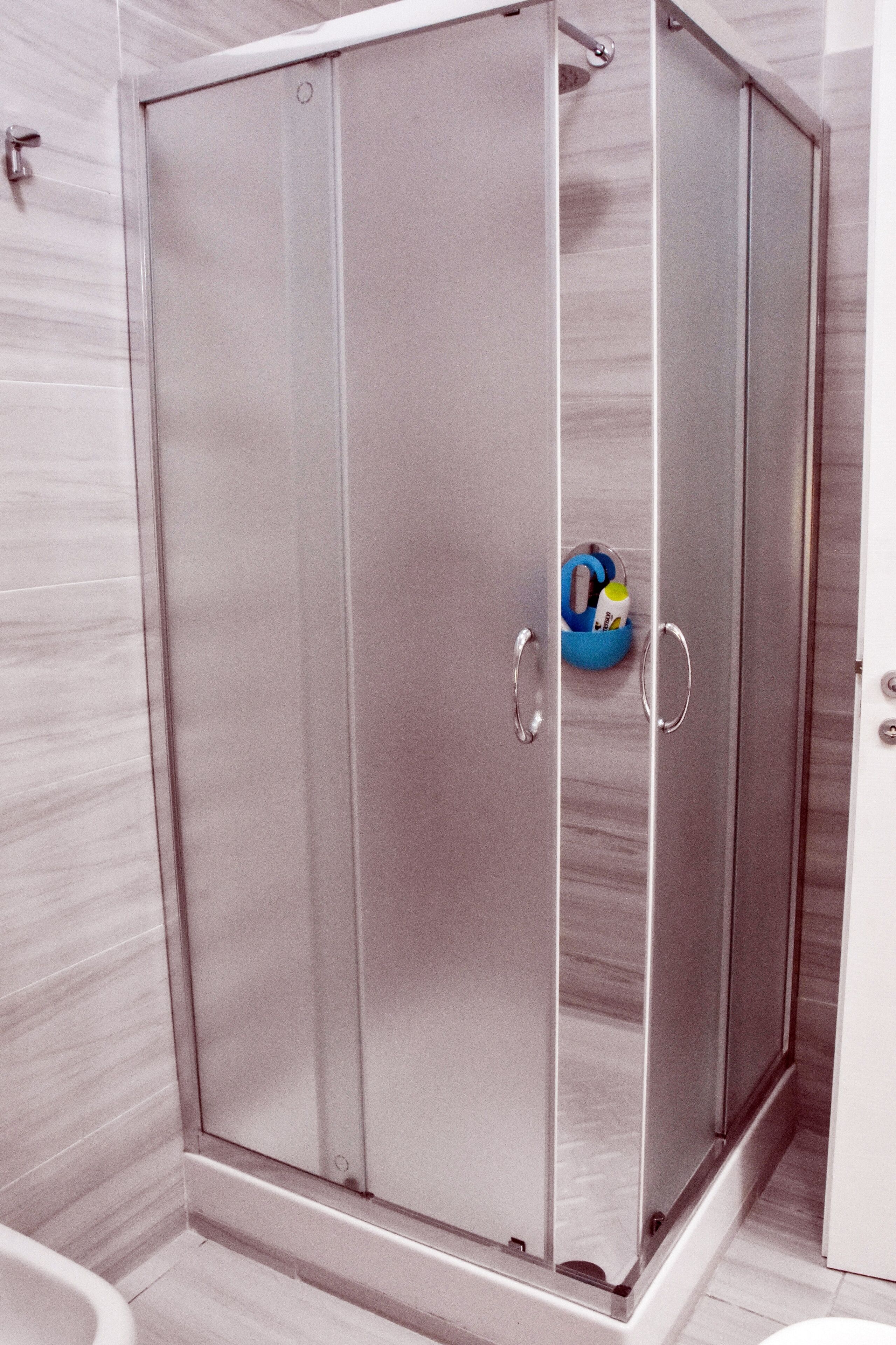 A modern bathroom with a walk-in shower, a toilet, and a sink.