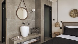Un baño moderno con un lavamanos grande, espejo y espacio para toallas.